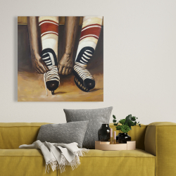 Toile 36 x 36 - Un joueur de hockey attachant ses patins
